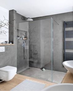 a bathroom with a toilet, sink and shower stall in the middle of the room