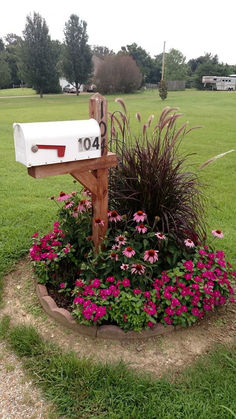 a mailbox sitting in the middle of a flower bed