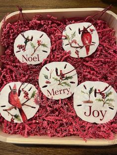 four christmas ornaments in a box with the words noel, merry and joy on them