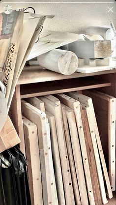 a wooden shelf filled with lots of different types of woodworking tools and paper on top of it