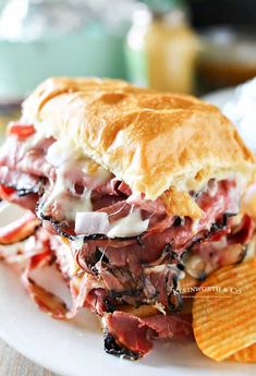 a sandwich and potato chips on a white plate