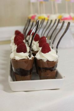 chocolate desserts with raspberries and whipped cream are arranged on a white plate