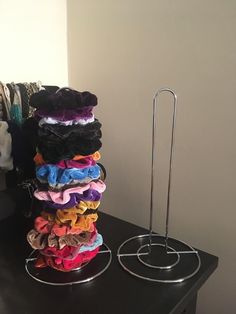 a stack of cloths sitting on top of a black table next to a metal rack