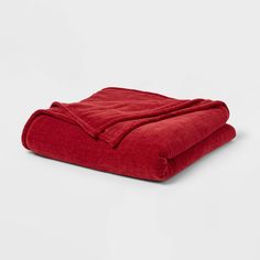 a red blanket is folded on top of a white surface