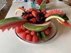 watermelon, strawberries, grapes and other fruits are arranged in the shape of a bird