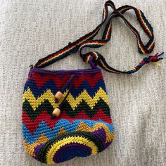 a crocheted purse with a wooden button on the side and a string attached to it