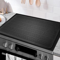 a stove top with utensils hanging on the wall