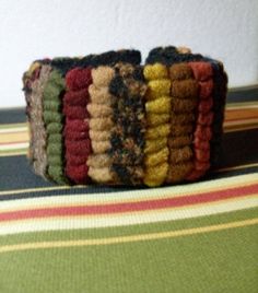 a stack of multicolored knitted bracelets sitting on top of a table