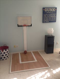 a basketball court in the corner of a room with a dunk board on it