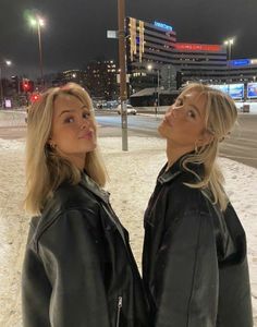 two women standing next to each other in the snow