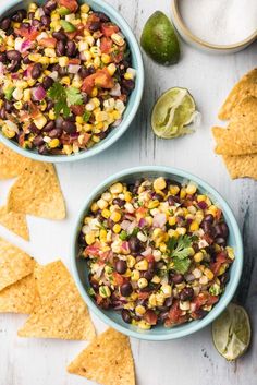 two bowls filled with black beans, corn and salsa next to tortilla chips