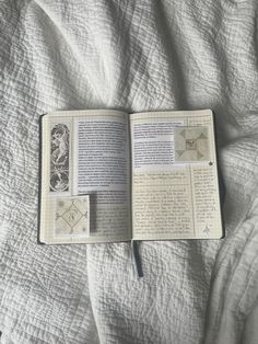 an open book sitting on top of a bed