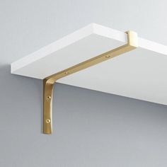 a close up of a wall shelf with a light on the top and a metal hook attached to it