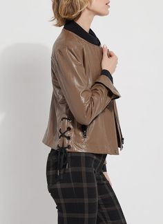 Made from 4-way stretch Textured Vegan Leather, the Kellie Bomber Moto Jacket features a cropped, slim fit, zip front, contrast-color ribbed jersey neck, back yoke, side pockets and gunmetal zip sleeves for easy cuffing. Combining bomber and moto jacket styling, the Kellie is an unlined jacket with a mesh yoke inside and a unique, side lace-up detail with metal eyelet and side ties. Layer the Kellie Bomber Moto over our Connie Slim Button Down and Patterned Baby Bootcut pants. Vegan Leather- 100 Fitted Cropped Jacket With Zipper For Fall, Brown Fitted Outerwear With Asymmetrical Zip, Fitted Brown Outerwear With Asymmetrical Zip, Fitted Cropped Jacket With Zip Fly For Fall, Chic Stretch Outerwear With Zipper Closure, Sleek Stretch Outerwear For Fall, Versatile Fitted Brown Outerwear, Spring Fitted Outerwear With Metal Zipper, Fitted Spring Outerwear With Metal Zipper