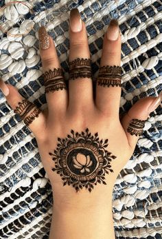 a woman's hand with henna tattoos on it