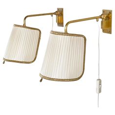 two wall lights with white shades on them