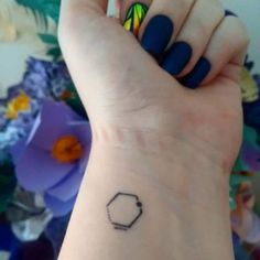 a woman's wrist with a small tattoo on it