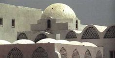 an old building with many windows and domes on the top, in front of a cloudy sky