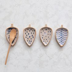 three wooden spoons with different designs on them