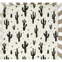 a crib sheet with black and white cacti on it