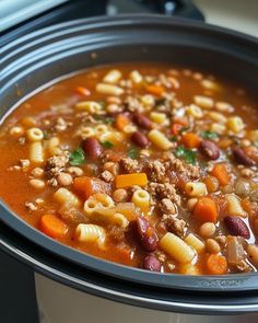 a crock pot filled with pasta and meat soup