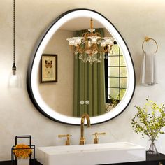 a bathroom with a sink, mirror and chandelier hanging from it's ceiling