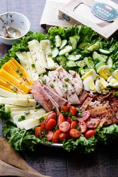 a salad with meat, cheese, tomatoes and cucumbers