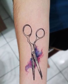 a pair of scissors tattoo on the arm