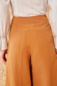 Our Polina Pant is a cropped, wide-leg beauty made from our signature suiting fabrication in a versatile tan hue. Exclusive to our boutiques and webshop, these high-rise pants are adorned with double-breasted buttons and are designed without a waistband for a sleek finish. Composition: 53% Cotton, 45% Linen, 2% Silk Style with our Arden Blouse and Mini Flower Stud Earring to complete the look. Elegant Cotton Culottes, Elegant High-waisted Cotton Culottes, Beige Wide Leg Culottes For Workwear, Chic Cotton Straight Culottes, Classic Wide Leg Culottes For Spring, Beige Workwear Culottes With Pockets, Cotton Straight Leg Culottes For Work, Spring Straight Culottes With Belt Loops, Cotton Culottes For Fall