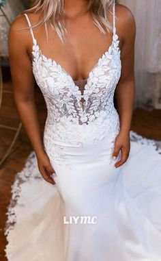 a woman in a white wedding dress posing for the camera with her hands on her hips