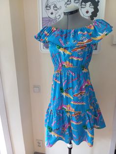 Very cute dress with beach print. The dress features flounces at the top and end of skirt and has elastics to waist. Material iscotton and it looks homesewn but nicely done. Length 88cm Bust 90cm Waist 90cm  Seat 94cm Cotton Dress With Vibrant Print For Vacation, Casual Multicolor Print Dress For Vacation, Casual Multicolor Print Dress For Beach Party, Casual Multicolor Print Vacation Dress, Casual Multicolor Tropical Print Dress, Beach Tropical Print Dress, Cotton Graphic Print Dresses For Vacation, Casual Printed Dresses For Beach Party, Multicolor Print Cotton Dress For Vacation