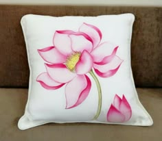 a white pillow with pink flowers painted on it