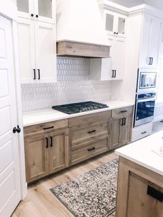 a kitchen with white cabinets and wooden floors