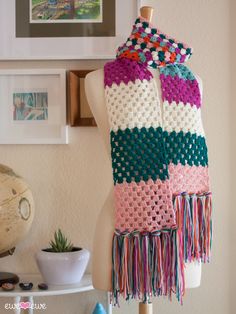 a crocheted scarf is hanging on a mannequin's dummy in a room