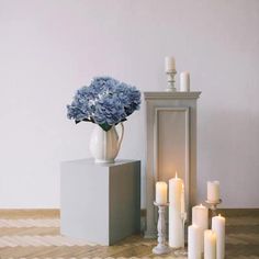 there is a vase with flowers and candles on the floor