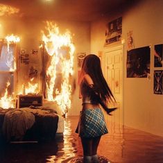 a woman standing in front of a bed covered in fire