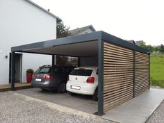 two cars parked in a carport next to each other on the side of a building