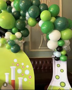 green and white balloons are in vases on the table