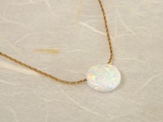 "Elegant and simple. This necklace made with a lab Opal coin charm and a delicate sterling silver / gold filled chain. This necklace is perfect for the woman who loves simplistic yet stunning fashion. Perfect for everyday wear and layering, this necklace will add a hint of elegance to any outfit. Necklace features: - Lab Opal charm measures 10mm - All components are 100% sterling silver / gold filled - Shown at 16\" on the model Comes beautifully wrapped and ready for gift giving! Enter Shop her Gold Opal Necklace, Stunning Fashion, Blue Opal Necklace, Necklace Opal, Jewelry Elegant, Opal Beads, Necklace White, Disc Necklace, Necklace Blue