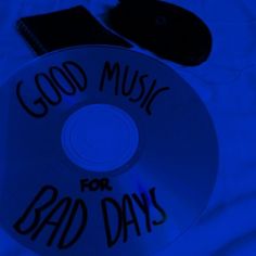 a cd with the words good music for bad days written on it and a cell phone next to it