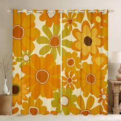 an orange and yellow floral curtain hanging in front of a white wall with a lamp next to it