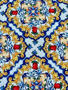 an artistic tile design with red flowers and leaves on blue, yellow and white tiles