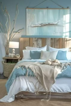 a bedroom with blue walls and white linens on the bed, along with an ocean themed painting