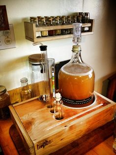 a wooden table topped with a large bottle and two glasses filled with liquid on top of it