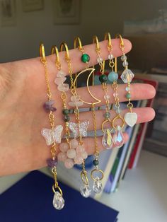 a person's hand holding several different types of bracelets and rings on it