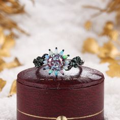 a diamond ring sitting on top of a wooden box in the middle of some snow