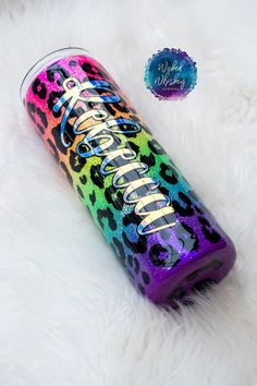 the colorful leopard print canister is next to a white fur covered floor with a blue tag