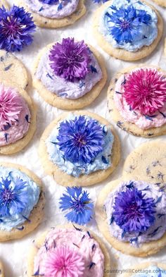 purple and blue flowers are on top of cookies