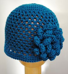 a blue crocheted hat on top of a wooden mannequin