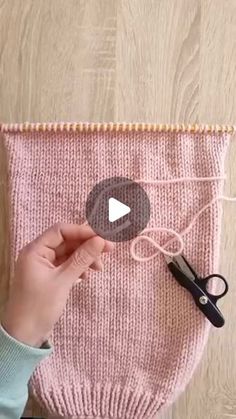 someone is making a knitted bag with scissors